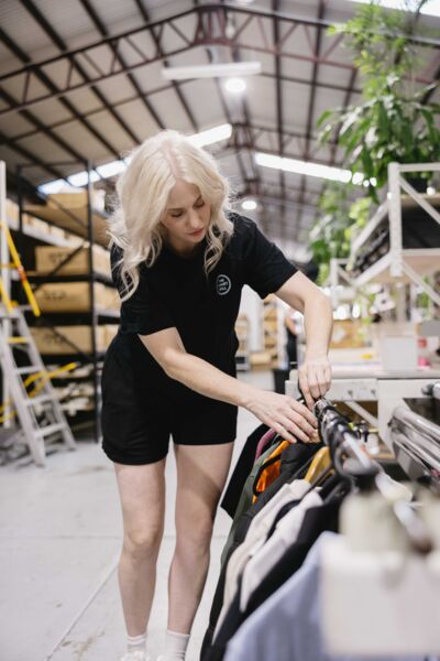 Pulling printed tees from the rail in the Newstead workshop