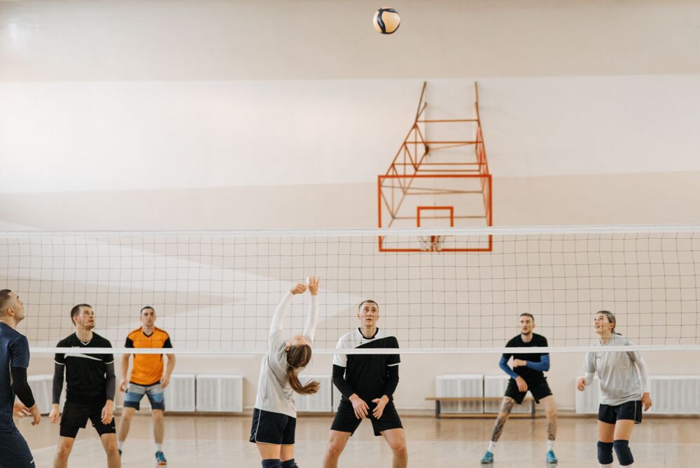 Mixed volleyball team at the net in matching tees