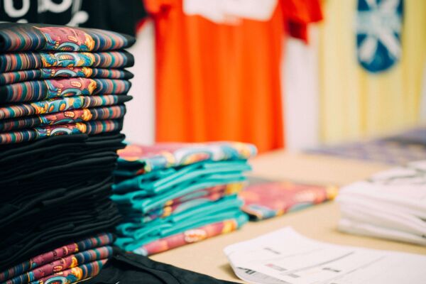 Stacks of freshly printed tees in a range of colours